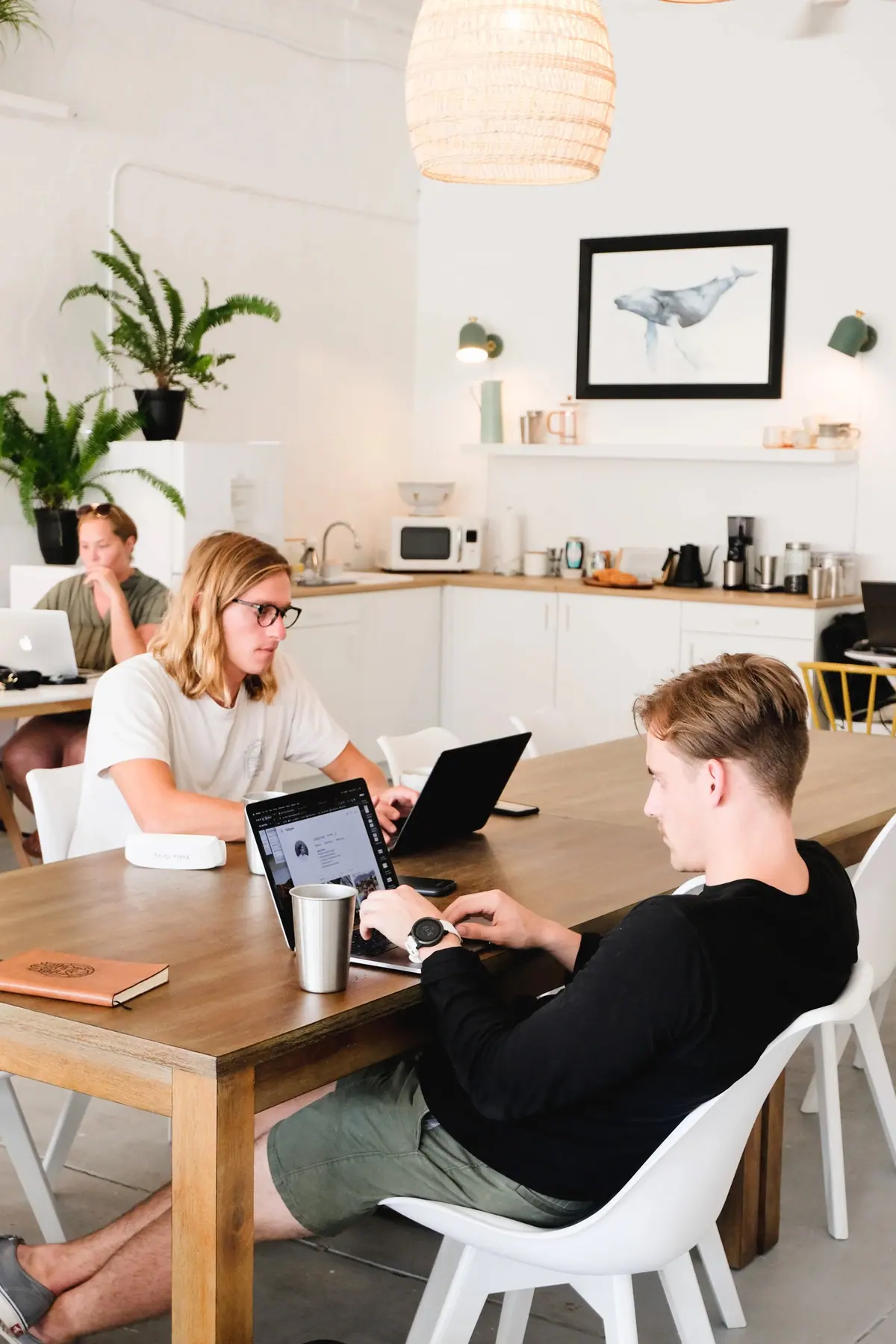 Members working around a long shared table at Coastal Coworking
